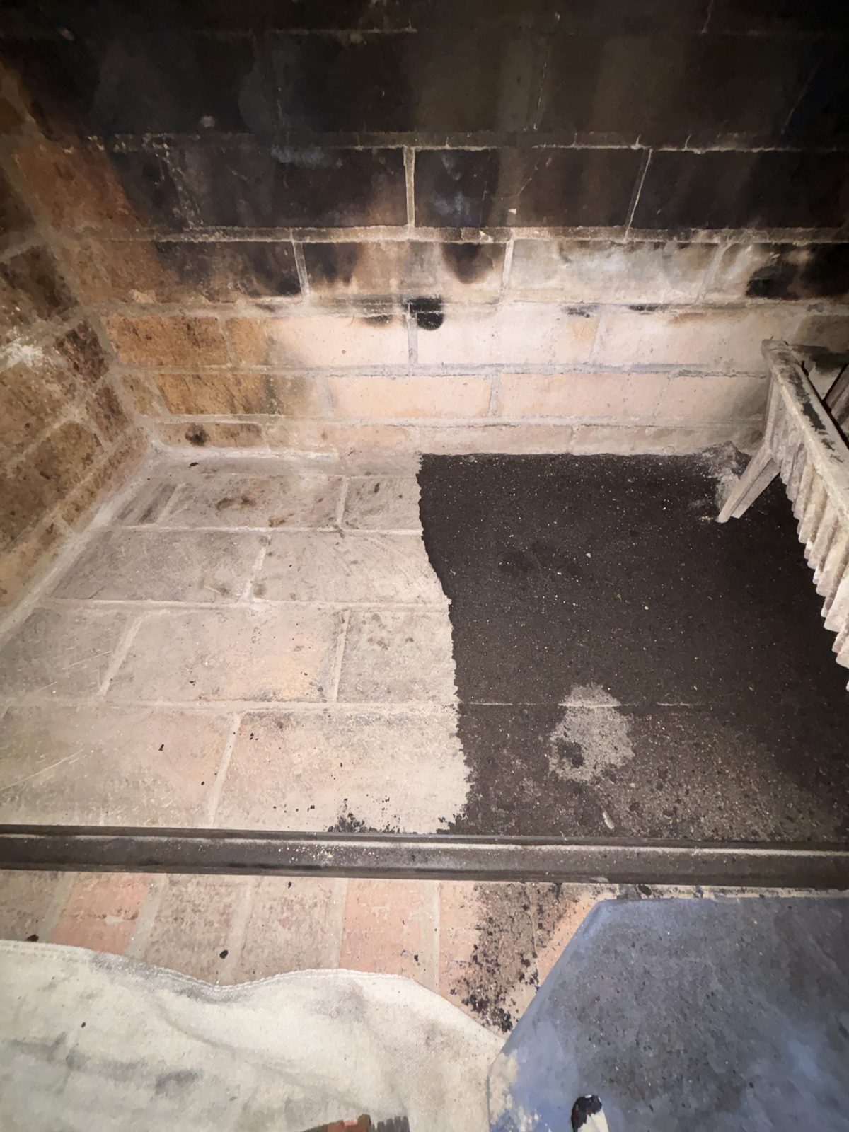 Soot-blackened masonry firebox before cleaning