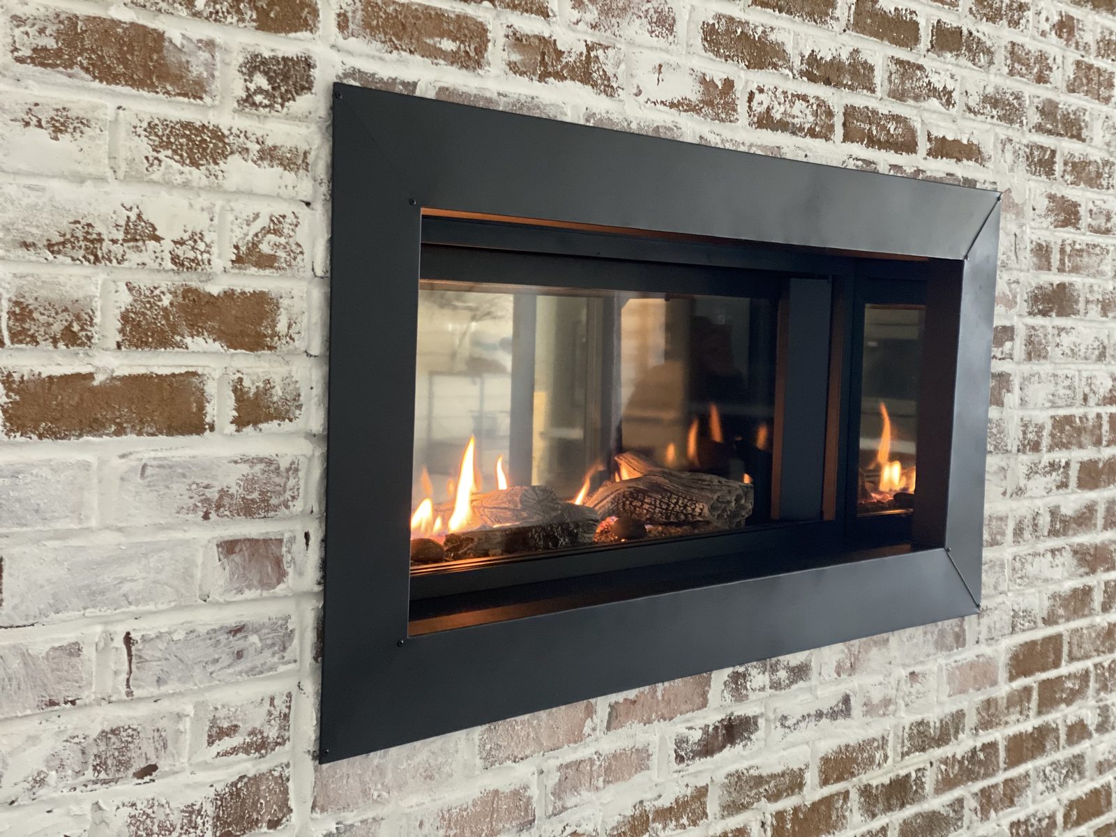 See-through gas fireplace in whitewashed brick