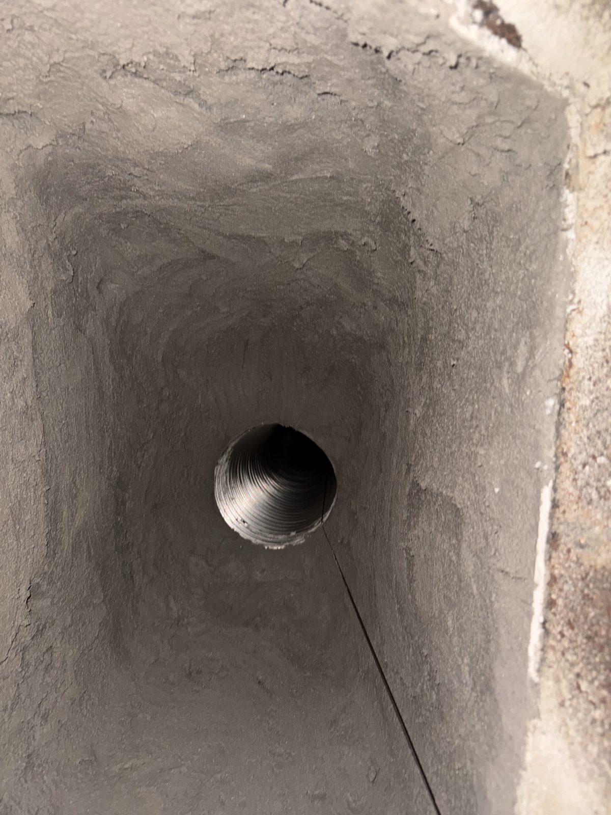 Looking down a parged masonry flue