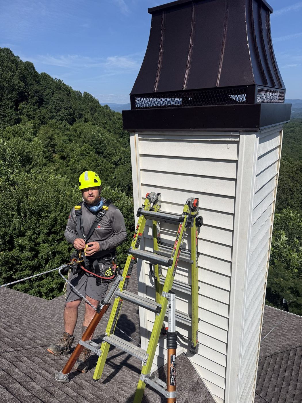 Technician in a harness working at a chimney top